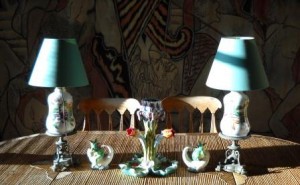 Objets sur une table de la salle à manger de la Villa Santo-Sospir sur fond de décorations murales de Jean Cocteau